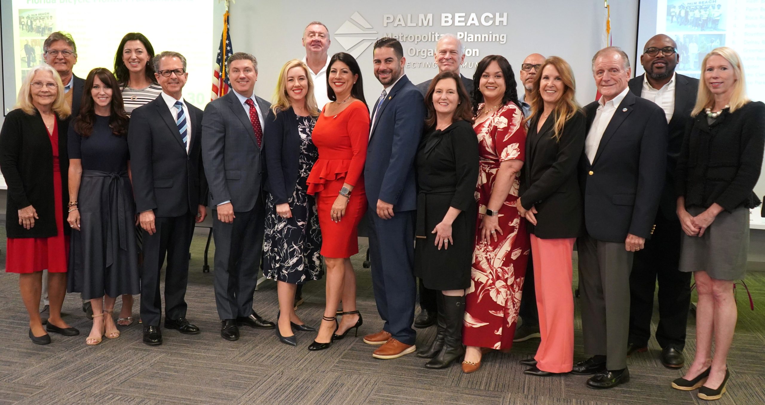 MPO Board members and Executive Director posing and smiling for a group photo in the MPO board room.